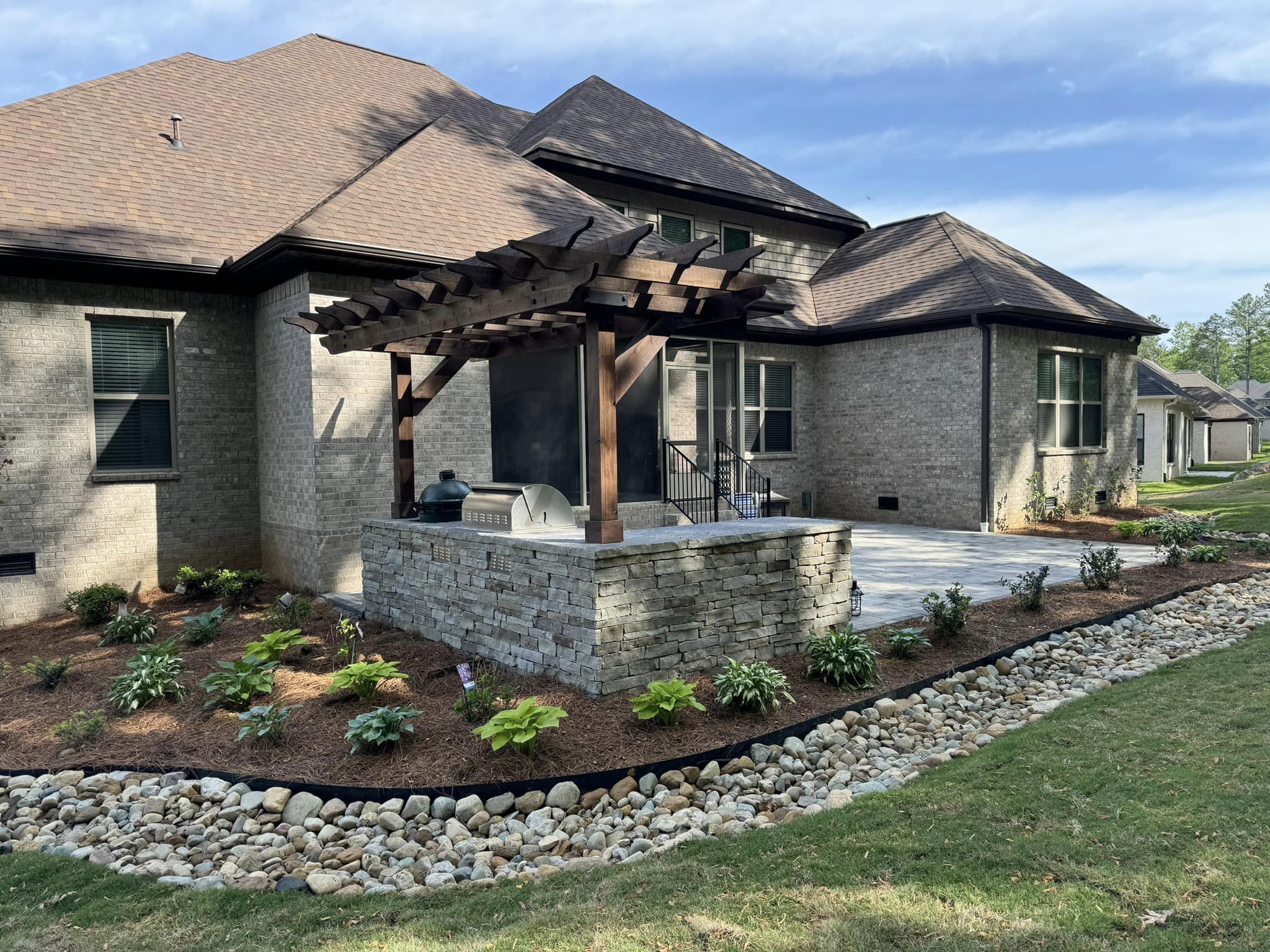 Backyard landscape with rocks and plants in Owens Cross Roads, AL